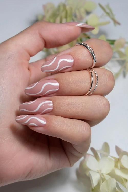 female hand with simple nail idea featuring nude and white colors