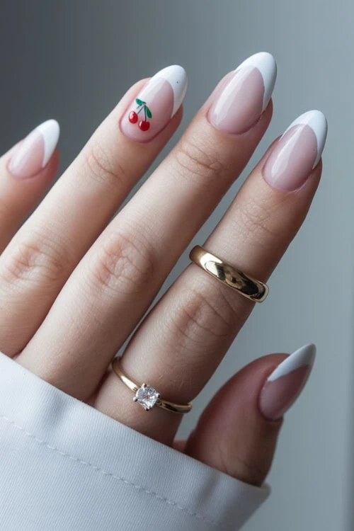 female hand with a french manicure and cherry nail art