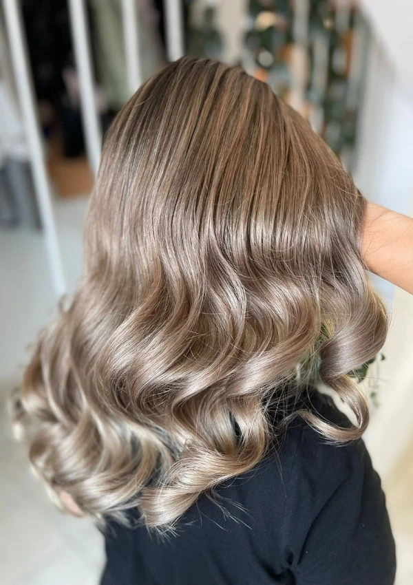 back of a woman's head with curly voluminous beige blonde hair