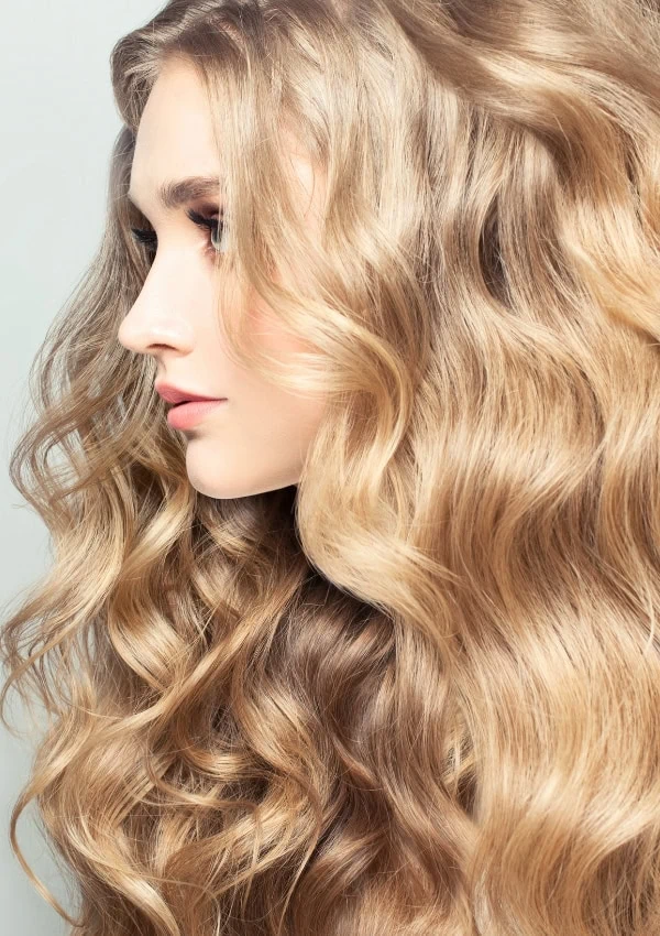 woman with thick curly butter blonde hair color