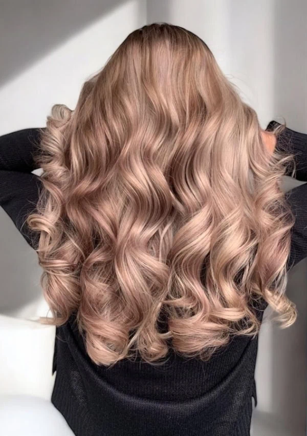 example of a rose gold Blonde Hair Color Idea that is the back of a woman's head with long curly hair
