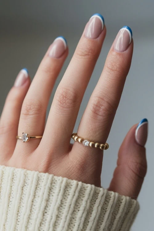 hand with blue and white french tip nails 