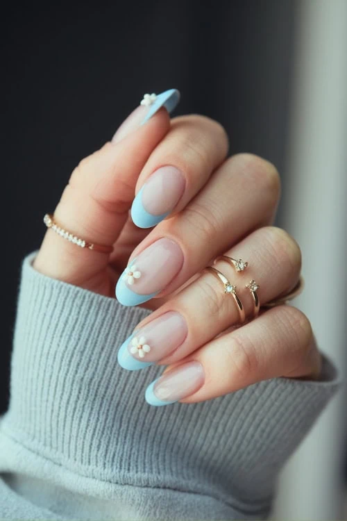 hand with light blue floral nail design