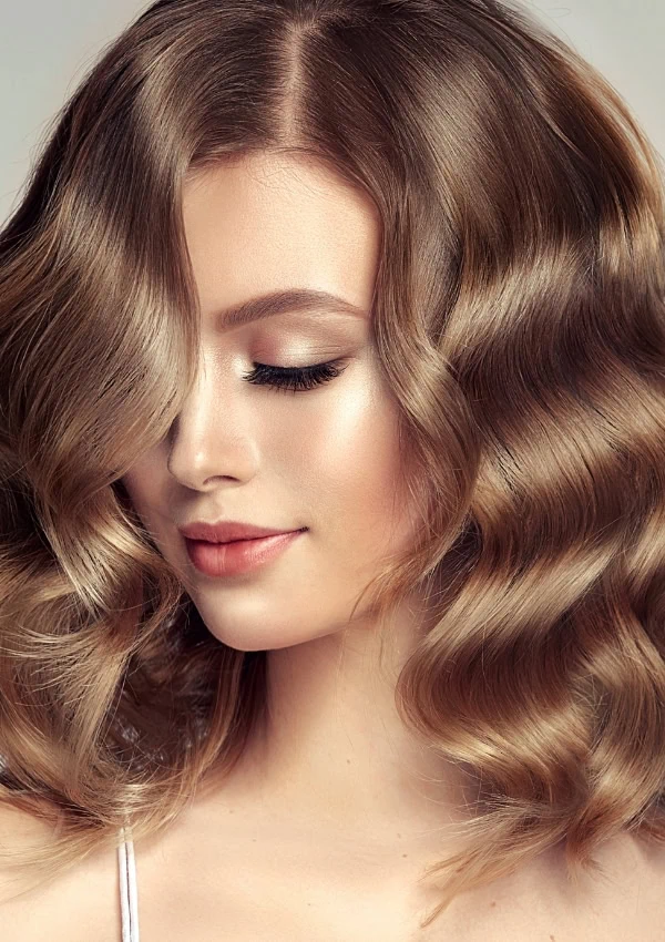 woman with wavy hair that is a mix of blonde and brown also called bronde hair color