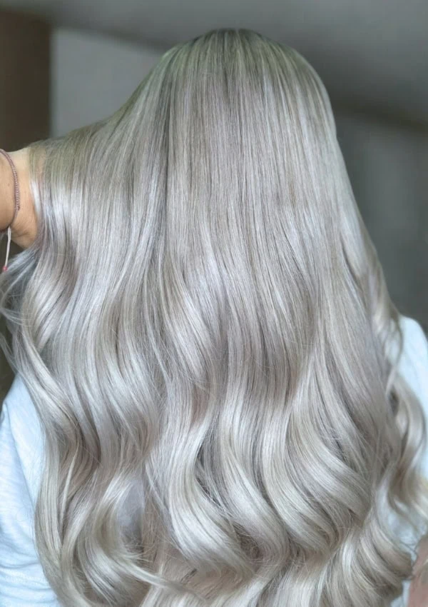 back of a woman's head with long wavy silver blonde hair