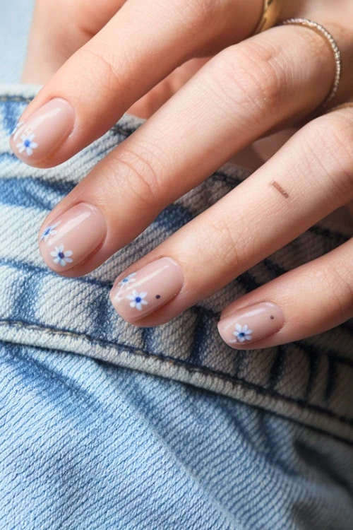 hand with simple blue nude nail idea and floral design