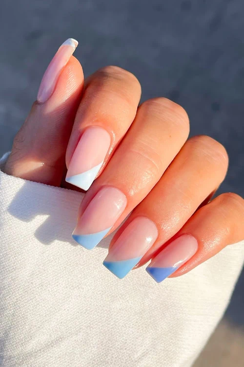 female hand with simple blue tipped nails