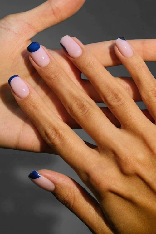 female hand with minimalist manicure with blue