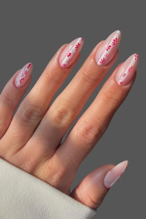 female hand with simple nails featuring a whte and red stripe