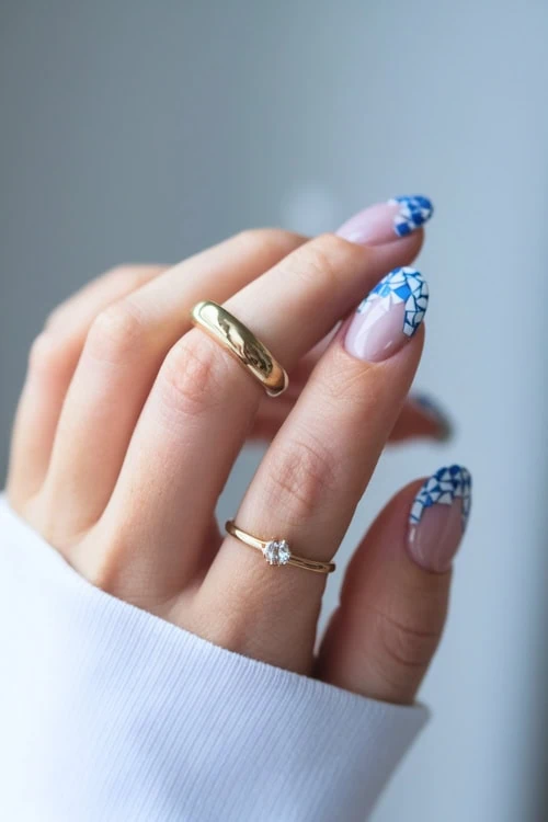 woman's hand with white and blue mosaic nails 
