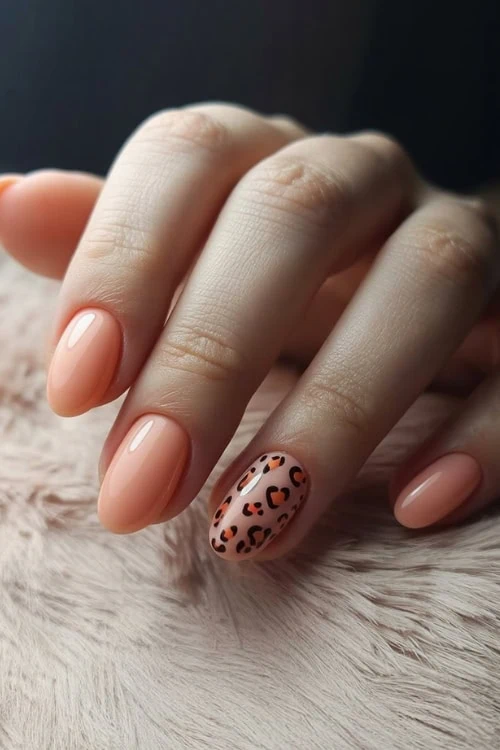 hand with peach nails and leopard print