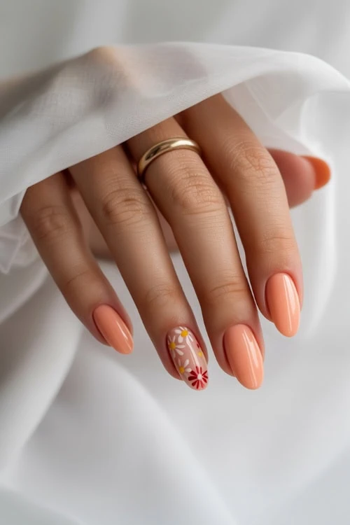 hand with glossy peach nails with floral nail art