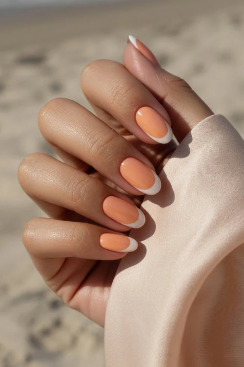 hand with peach nails that are french tipped with white