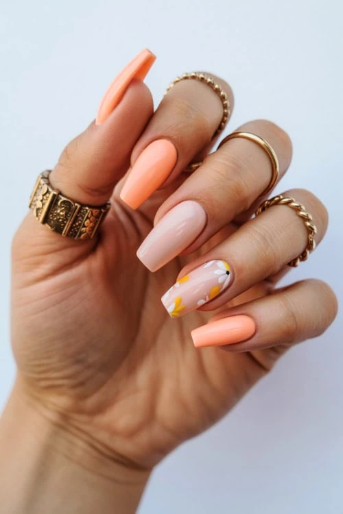 hand with peach and nude nails with floral design