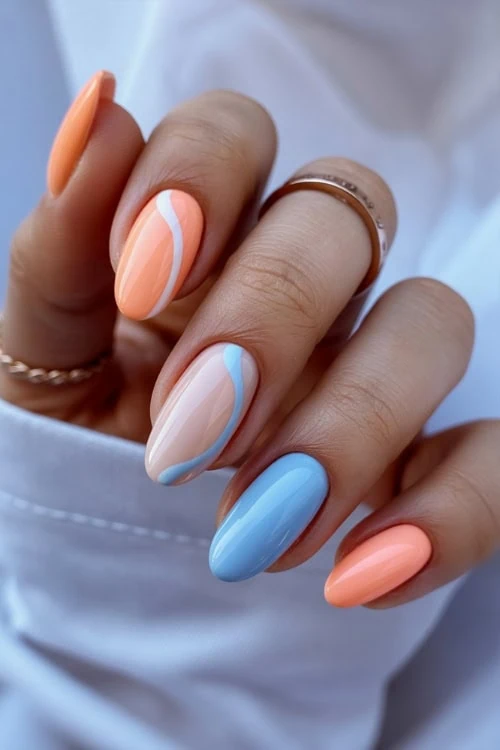 hand with peach nails and light blue nail design