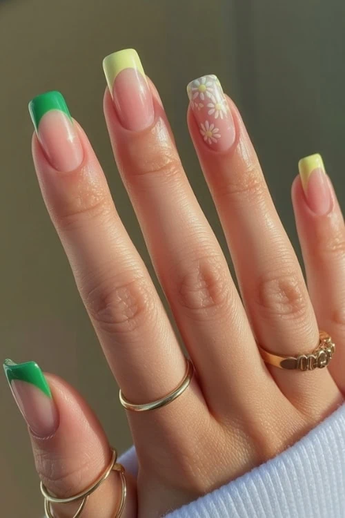 hand with FRENCH TIP NAILS in green and yellow with fowers