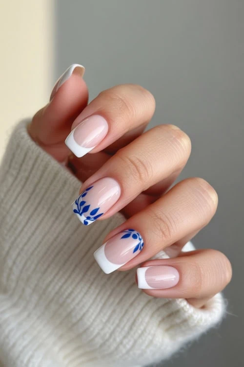 hand with white french manicure and blue vines