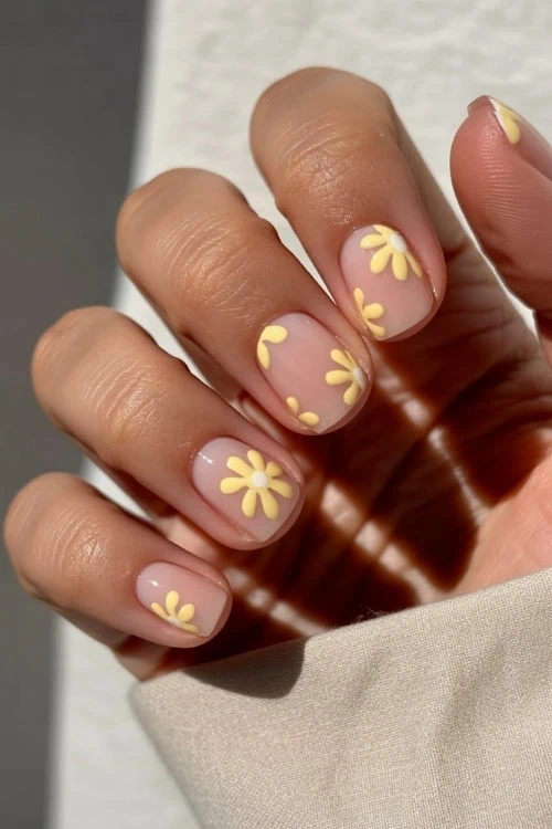 hand with short nails and yellow nail art design