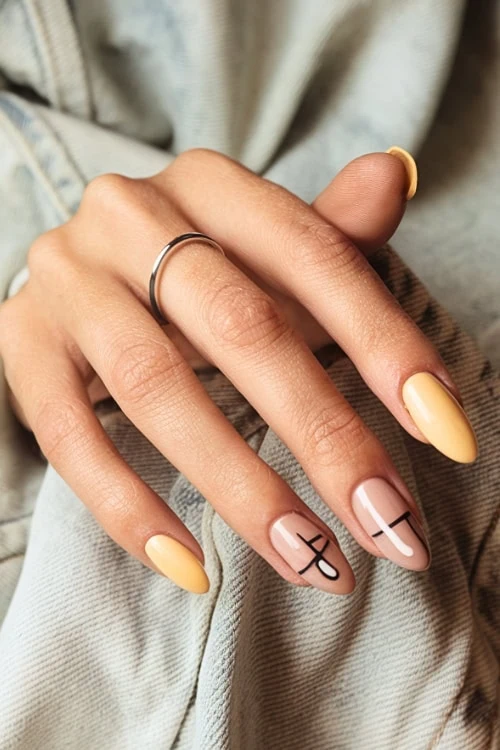 female hand with abstract nail art and yellow nails