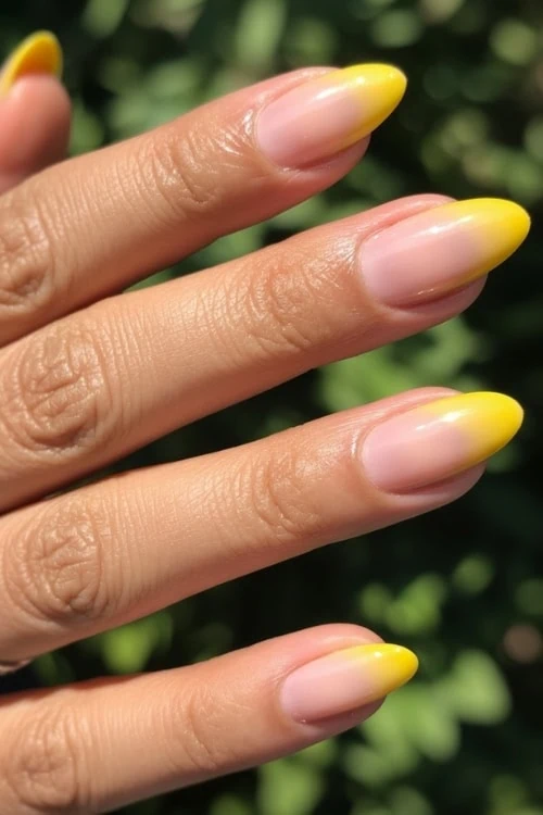 female hand with ombre summer yellow nails