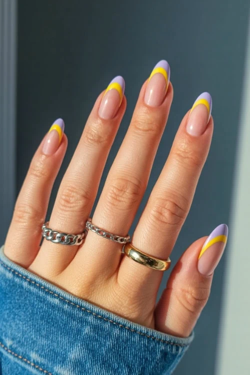 hand with purple and yellow french tip nail design