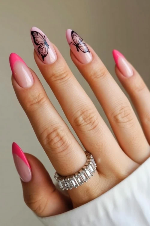 hand with almond nails pink tips and a butterfly design