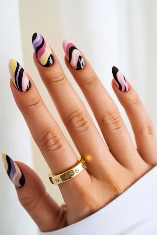 hand with almond nails and intricate colorful swirls