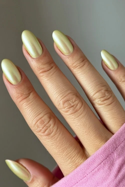 female hand with chrome yellow nails manicure