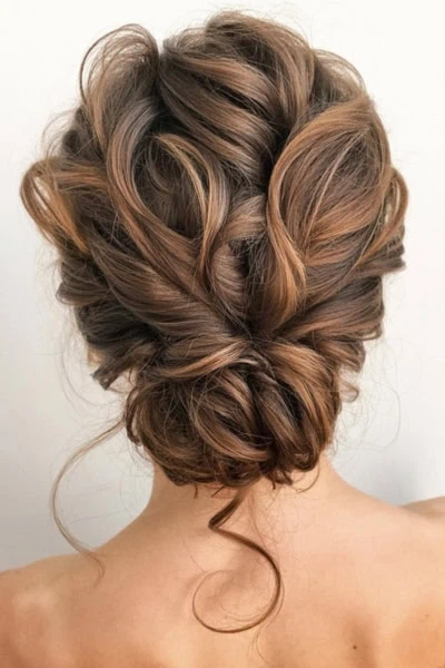 back of female's head with a formal hairstyle for long hair that has a elegant textured and touseled look