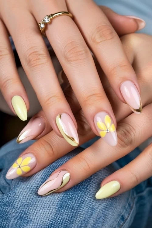female hand with trendy nails yellow nails design and gold