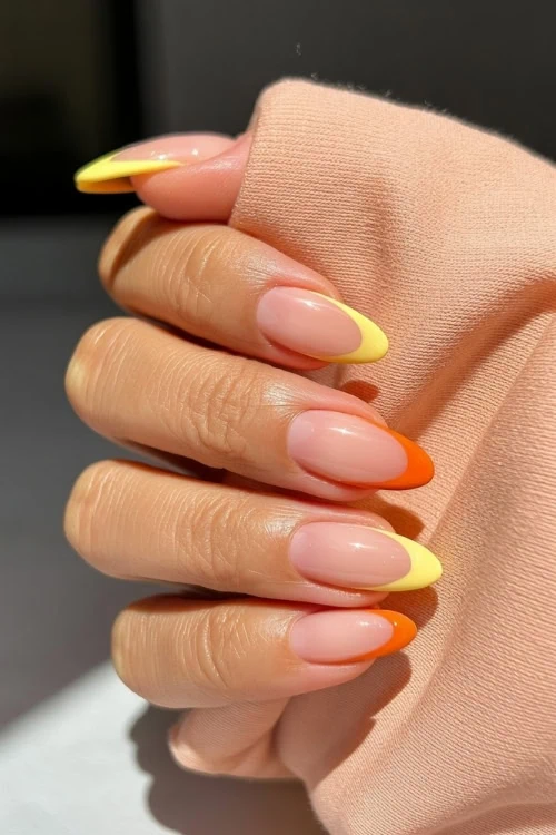 hand with yellow and orange nails design with French tips
