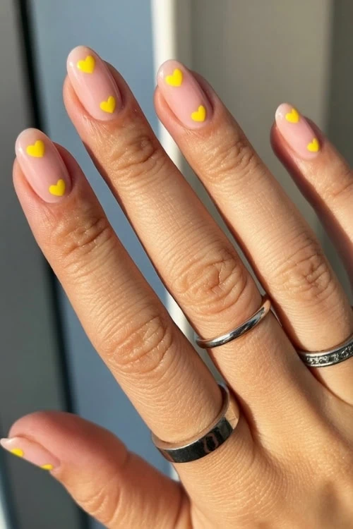 hand with yellow heart nail art