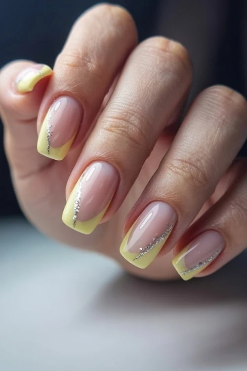 female hand with yellow nails design with silver