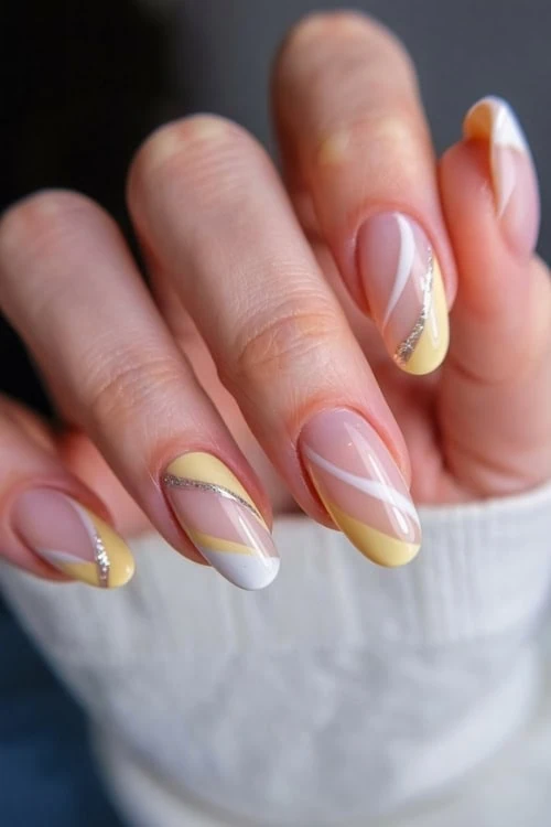 female hand with yellow nails design with white and silver