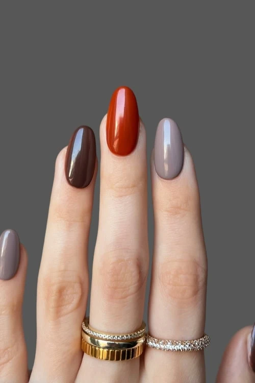 female hand with mulitcolored manicure featuring different color fall nails
