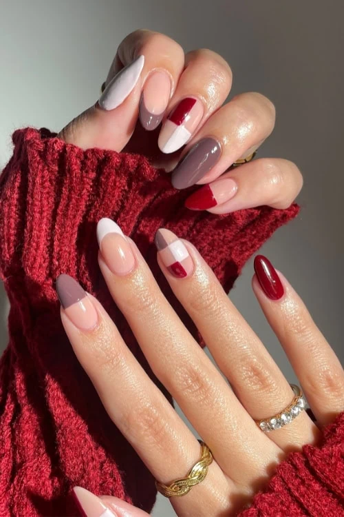 Female hands with berry tones, taupes, and white color block and French tip fall nails