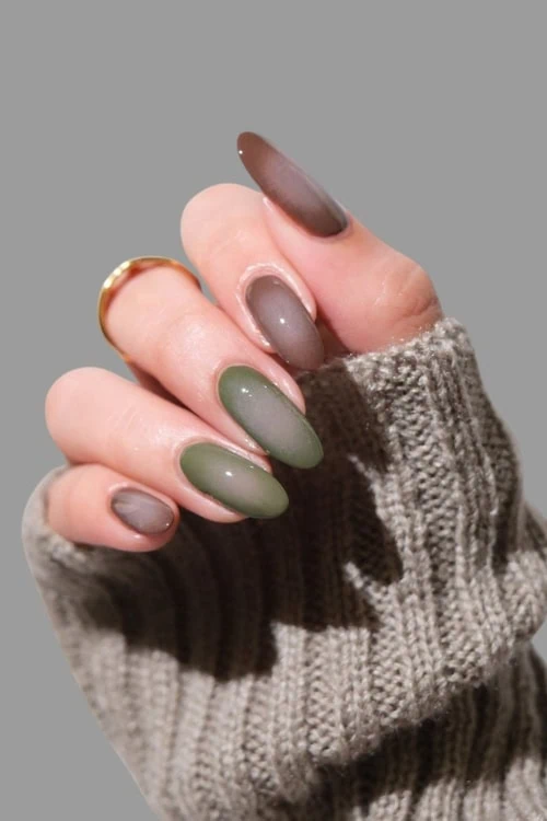 female hand with brown and green fall nails