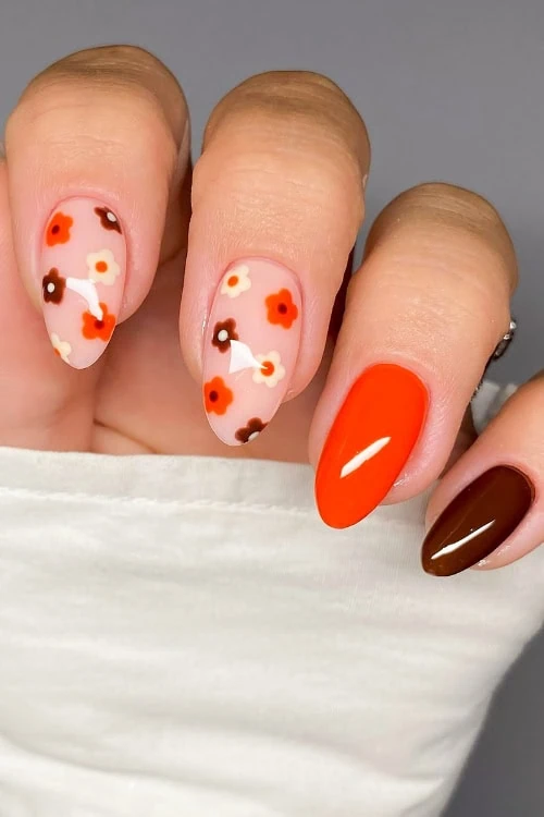 Female hand with orange and brown fall nails