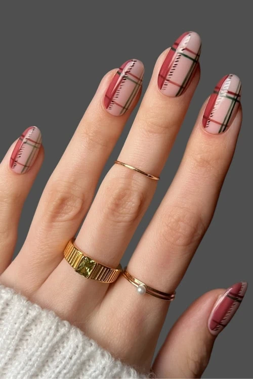 female hand with a fall themed manicure featuring a plaid nails design