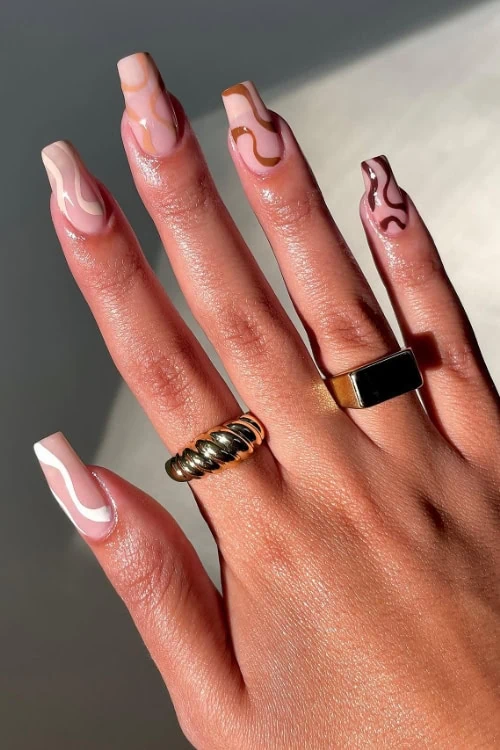female hand with fall manicure that has brown nails design