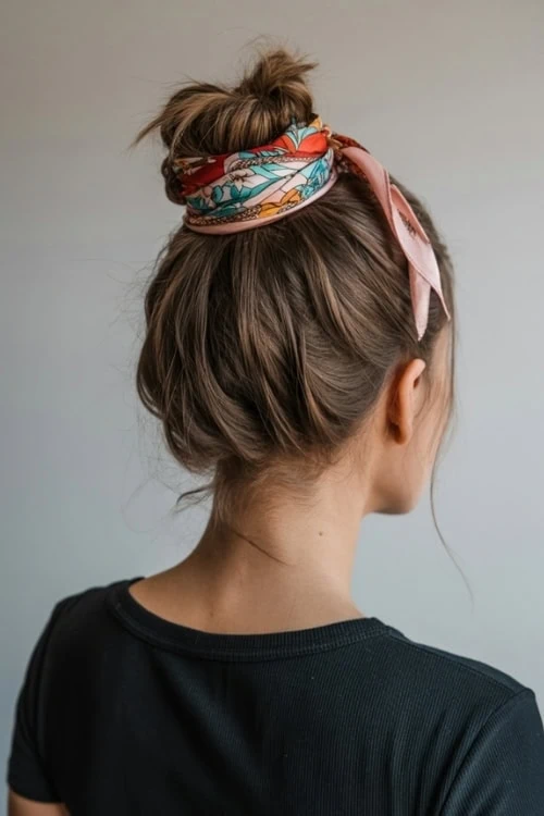 young woman with summer hairstyle high bun and scarf