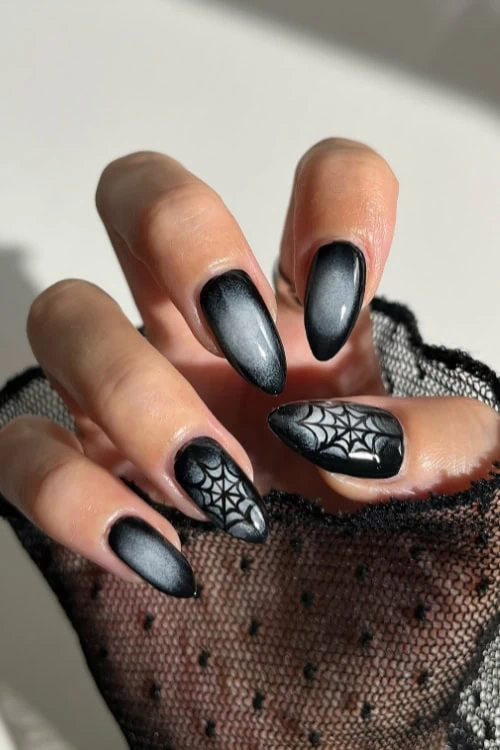 female hand with black halloween themed nails