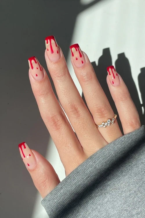 hand with halloween manicured nails with blood drops
