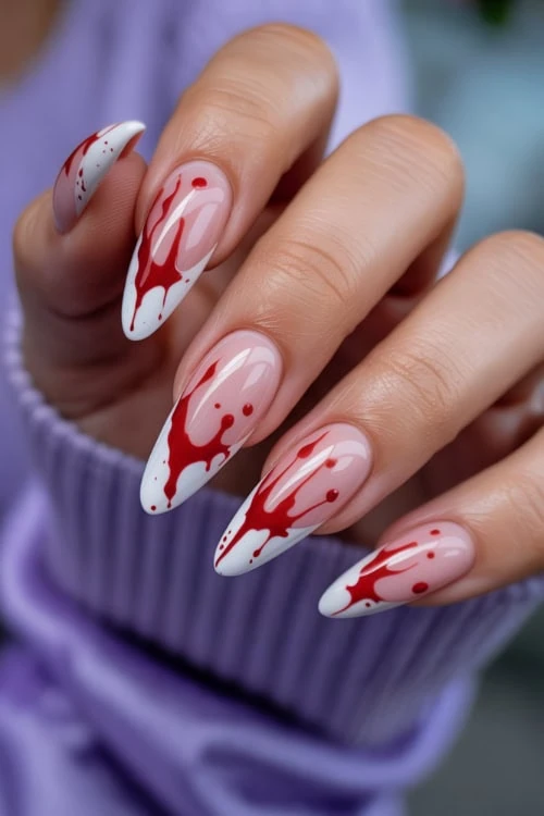 female hand with french tip nails and blood for halloween