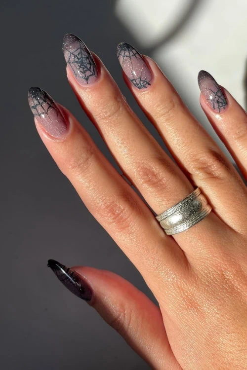 woman's hand with a halloween manicure with cobwebs