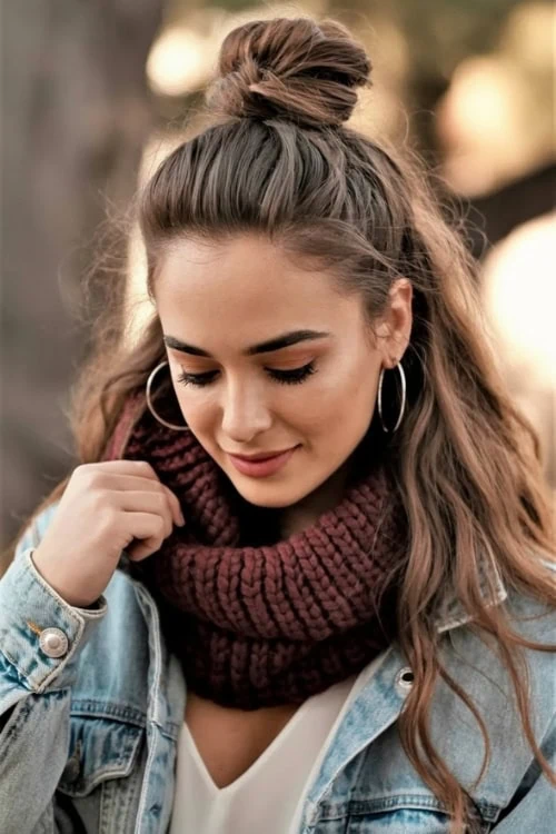 young woman walking outside on a fall day with a half up top knot hairstyle