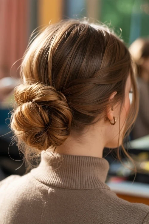 back of a woman's head with a low fall hairtyle which is a bun