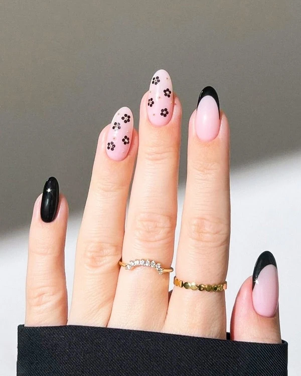 hand with black french tip nails and flowers