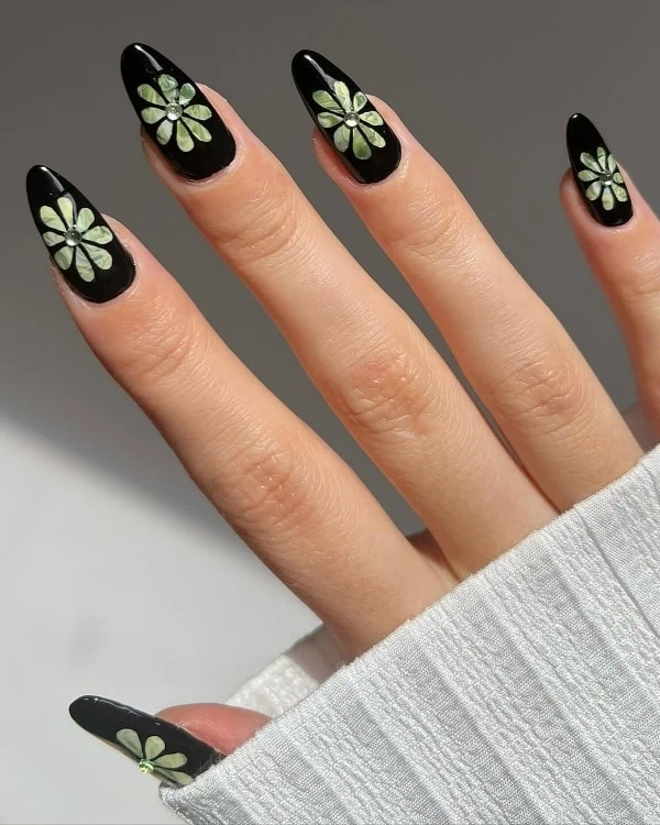 hand with black nails and green florals