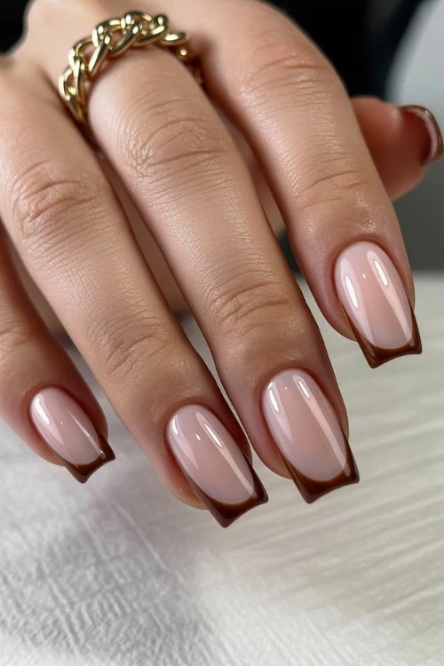 hand with crescent mocha french tip brown nails